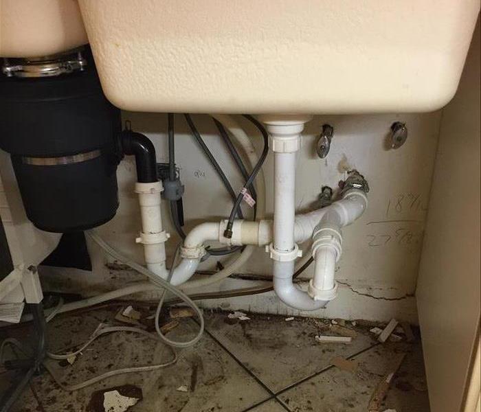 A water damaged sink, cabinets and drywall