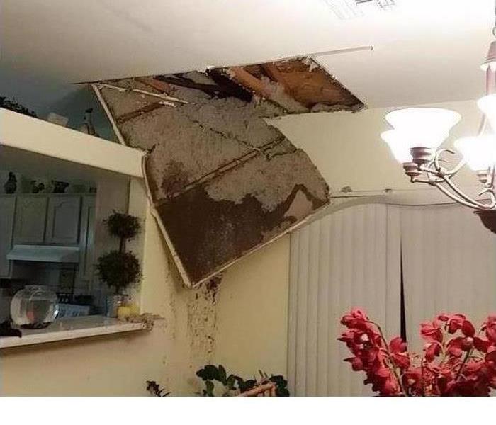 A ceiling with extensive water damage is shown beginning to fall